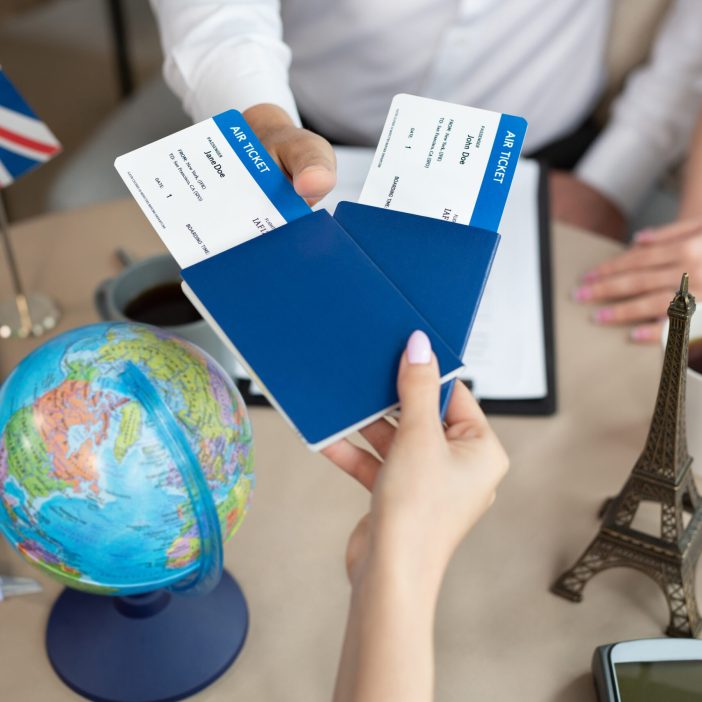 Close-up of passports and tickets in the hands of a travel agent in the office Ticketing biglietti